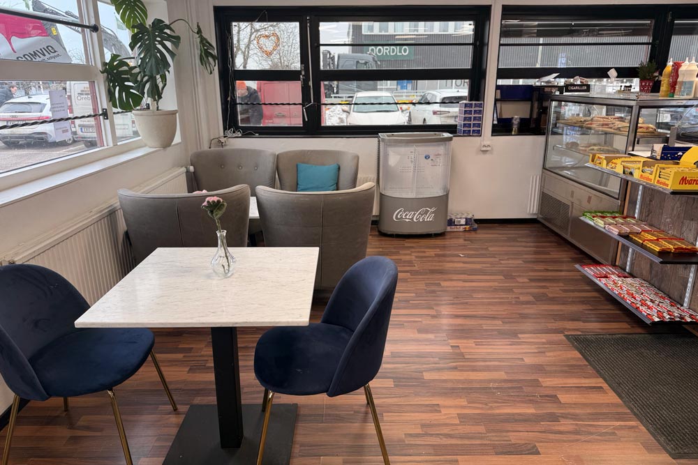 Sittplatser inomhus med bord och bekväma stolar för kaffe och paus